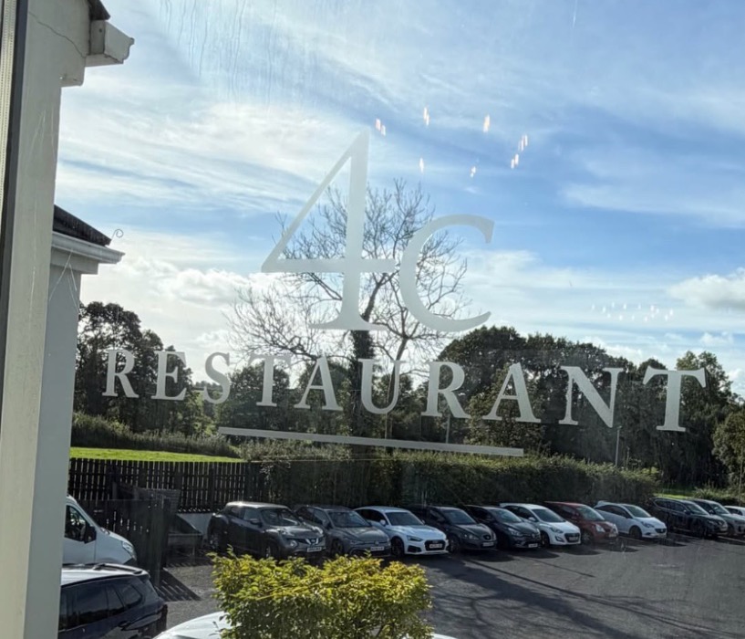 The 4C Restaurant logo on the front window, looking out over the car park